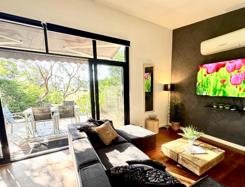 a living room with a couch and a large window at Nature Resort Villas - Villas with a View in Cowes