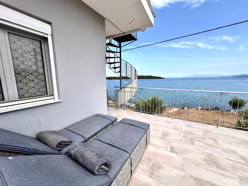 a bed on a balcony with a view of the ocean at ARTE MARE d'Irene in Spartos