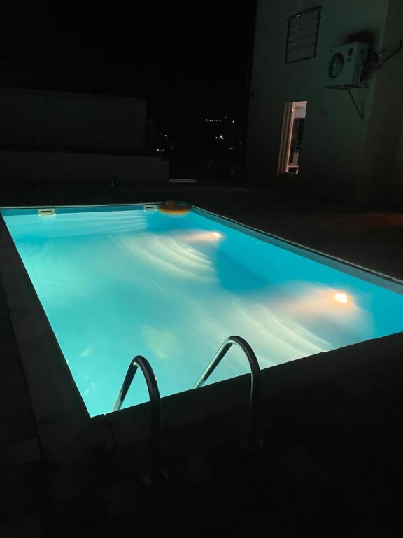 a swimming pool lit up at night with lights at Villa Pazar na dlanu in Novi Pazar