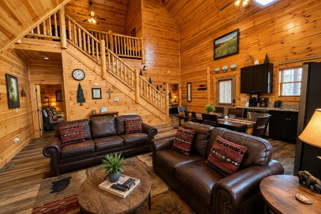 a living room with leather furniture in a cabin at Black Bear Lodge in Pigeon Forge