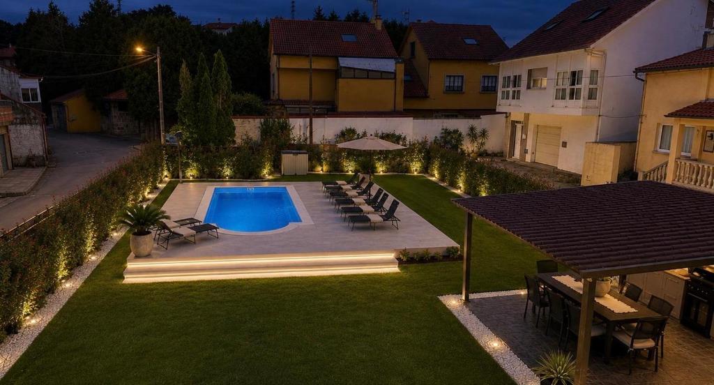 a backyard with a swimming pool and a yard with lights at Casa A LAXE in Vilagarcia de Arousa