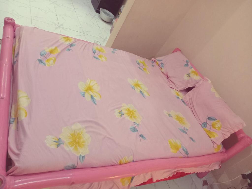 a pink bed with a pillow with flowers on it at Bed and breakfast, diner available in Djalabango