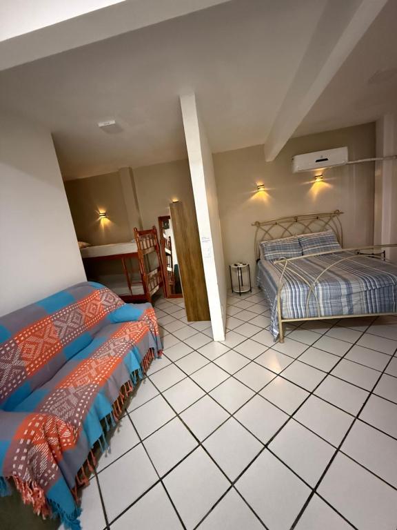 a bedroom with two beds and a tiled floor at KITNETS Kretzer Hinckel 2 - CENTRO in Alfredo Wagner