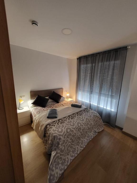 a bedroom with a bed and a large window at LUGO Stay in Lugo