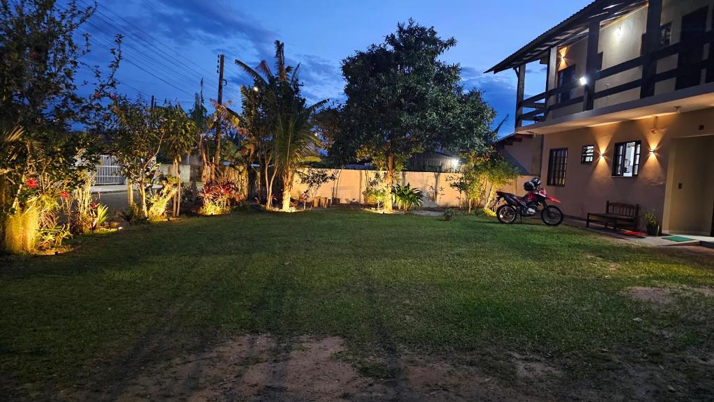 a yard with a motorcycle parked in front of a house at GH Pinheira in Palhoça