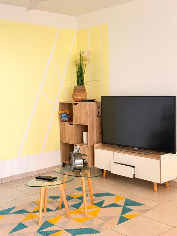 a living room with a large flat screen tv at Kessydryss in Sainte-Marie