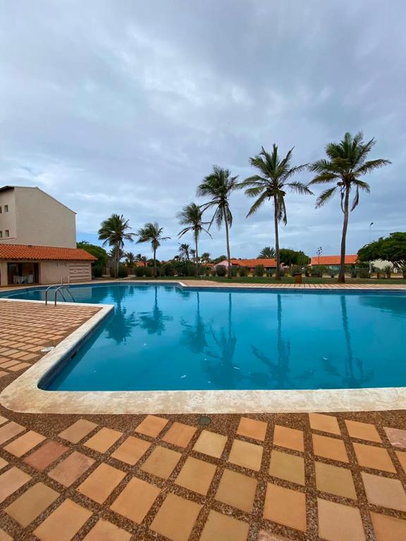 a large swimming pool with palm trees in the background at puerto real isla de margarita in La Playa