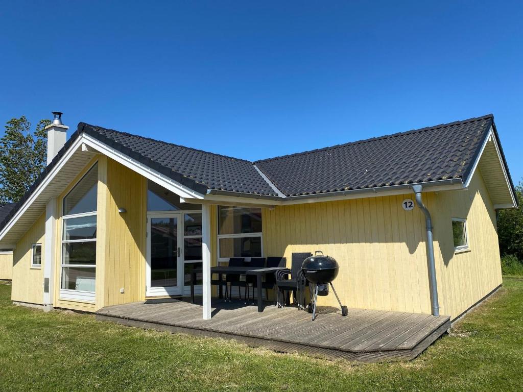 a house with a deck with a grill on it at Split-Wing House for Eight in Grossenbrode
