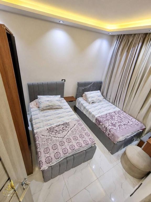 two twin beds in a room with a window at Portogolf elalamin in El Alamein