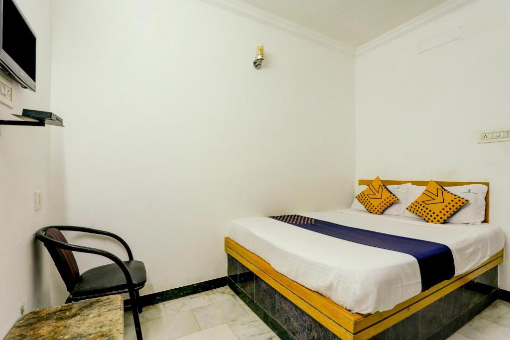 a bedroom with a bed and a chair in a room at SPOT ON JAYAM RESIDENCY in Chennai