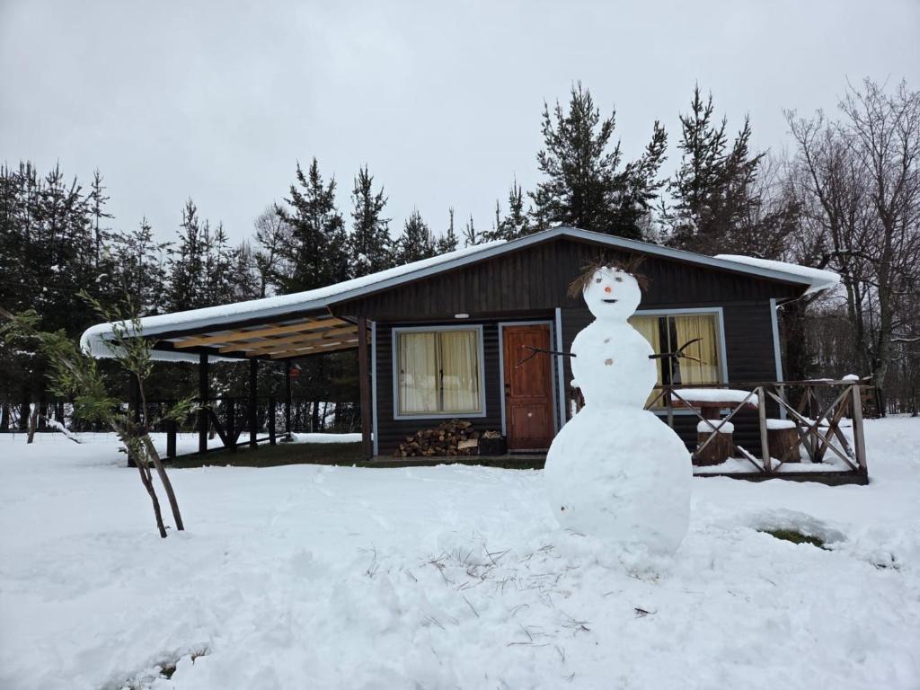 a snowman in the snow in front of a house at Paraíso Rustico 1 in Curacautín
