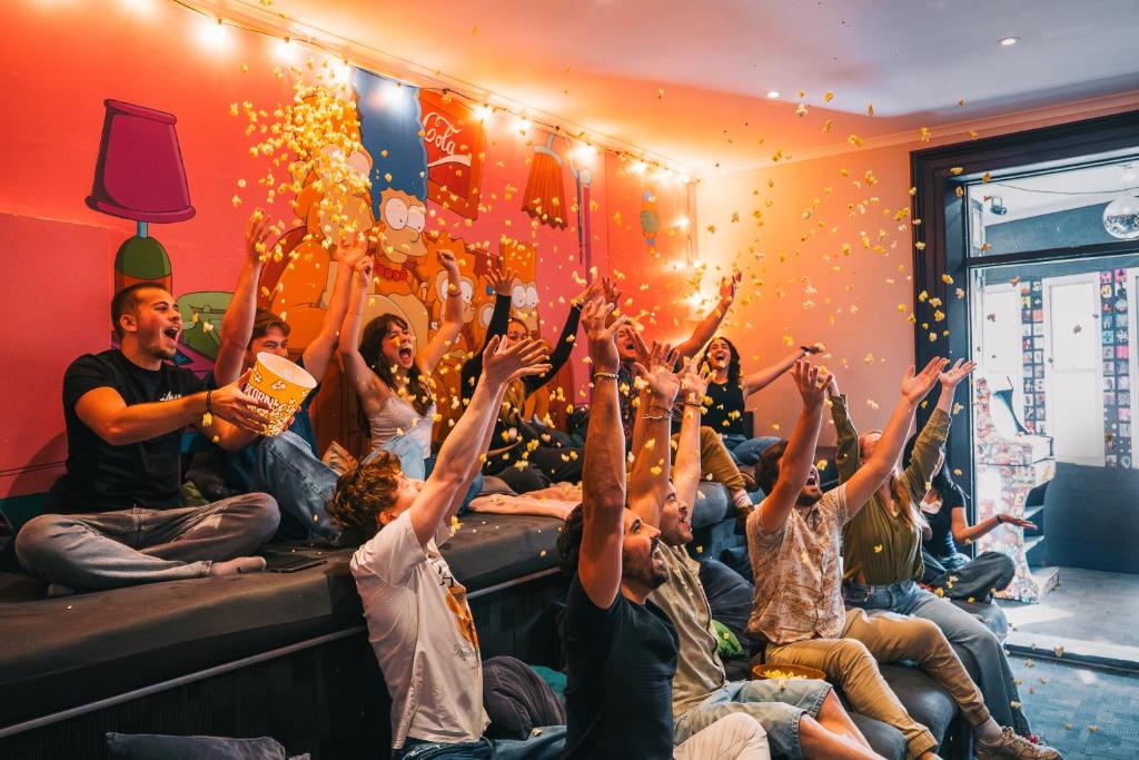 a group of people sitting on a bed with their hands in the air at Mad Monkey Kings Cross in Sydney