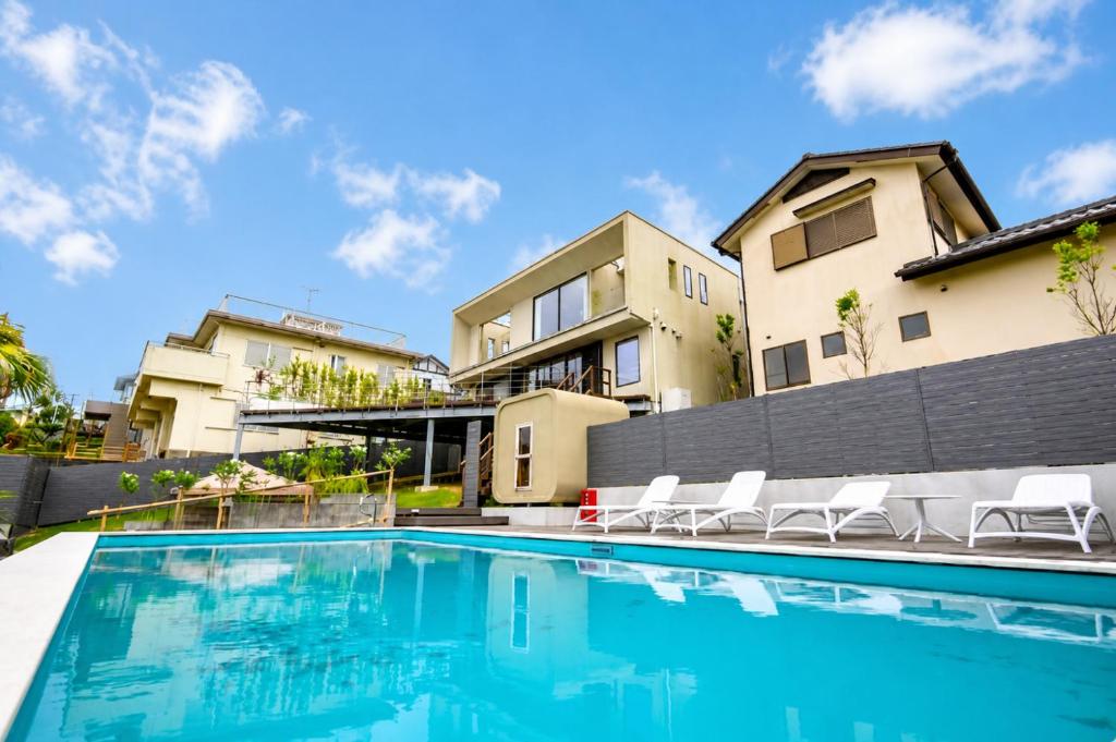 a swimming pool in front of a house at IPC Resort富津竹岡 in Futtsu