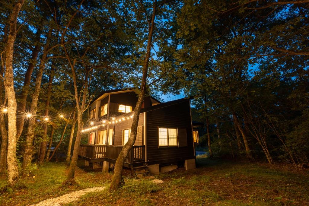 a tree house in the woods at night at クラレンス北軽井沢 - 4KプロジェクターとBBQ,焚き火を楽しむ森の貸切Villa - in Kita-karuizawa