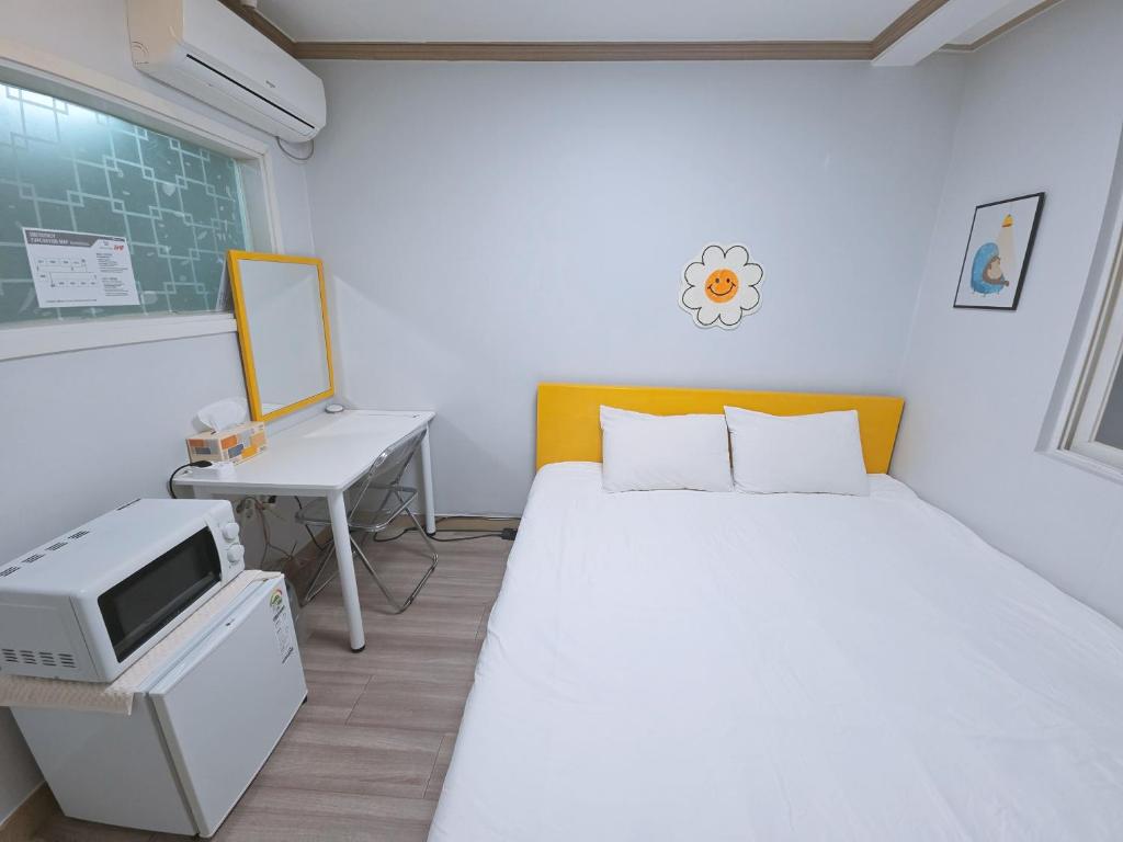 a bedroom with a bed and a desk with a computer at G Hotel near Busan Station in Busan