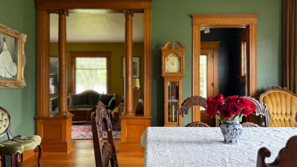 a room with a table with a vase of flowers on it at Spacious 4 BDR Historic Home in Heart of Sioux Center in Sioux Center
