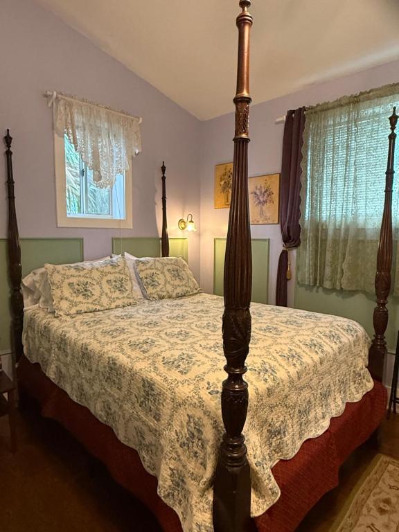 a bedroom with a bed with a wooden post at Penny Farthing Inn in St. Augustine