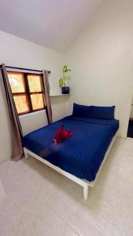 a bedroom with a bed with a red stuffed animal on it at Nomad house in Hin Kong in Ko Phangan