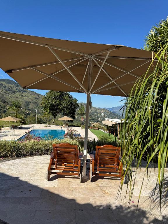 two chairs under an umbrella next to a pool at Finca Villa Rosita 26 in Copacabana