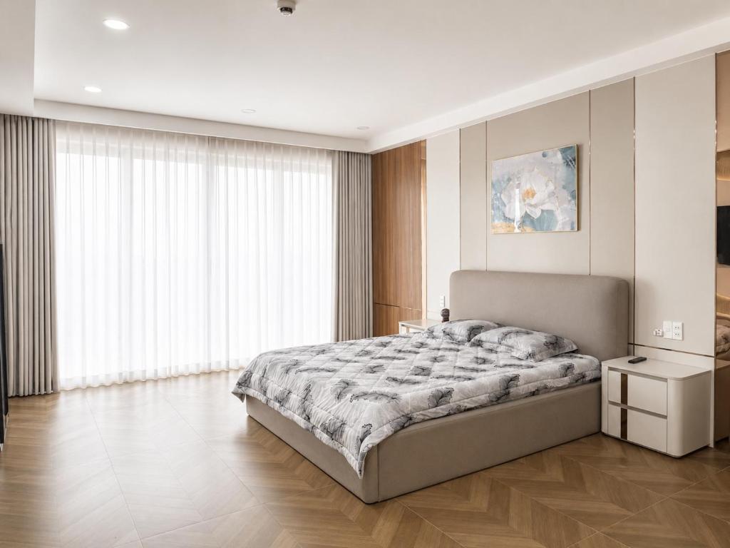 a bedroom with a bed and a large window at EcoCity Suites BMT in Buôn Enao