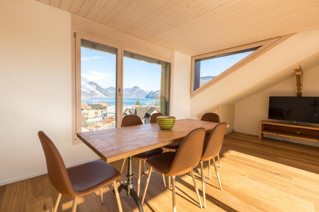 uma sala de jantar com mesa e cadeiras e uma grande janela em Pilatus Apartments em Alpnach