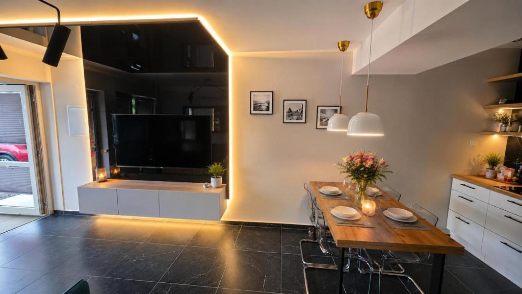 a kitchen with a wooden table and a television at Apartament Słowik Lux in Rowy