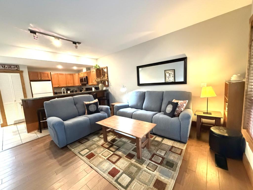 a living room with two blue couches and a table at Luxury Condo 2Bed, 1Bath, Pool, Hot Tub, Beach, Golf in Osoyoos