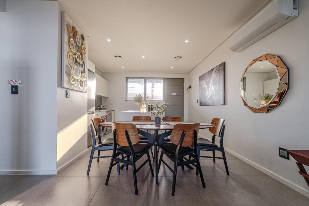 a kitchen and dining room with a table and chairs at Ocean Vista Pebble Beach in Umhlanga