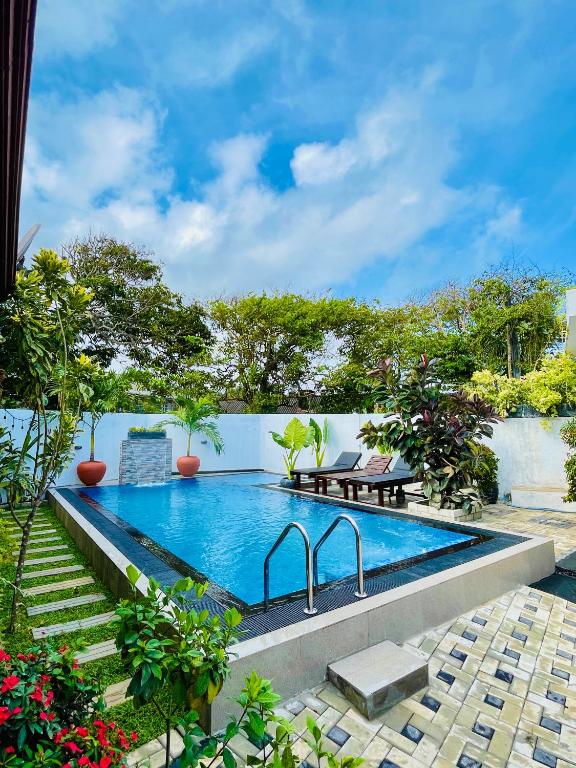 a swimming pool in the middle of a garden at Mount Top in Dickwella
