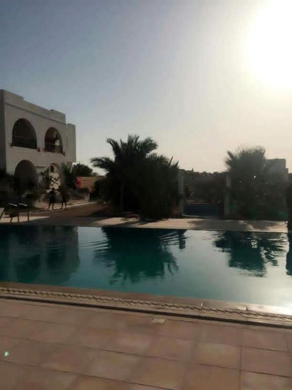 a large swimming pool in front of a building at maison djerbienne in Fafou