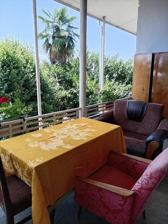 a yellow table and chairs with a palm tree in the background at Cabernet Tali in Telavi