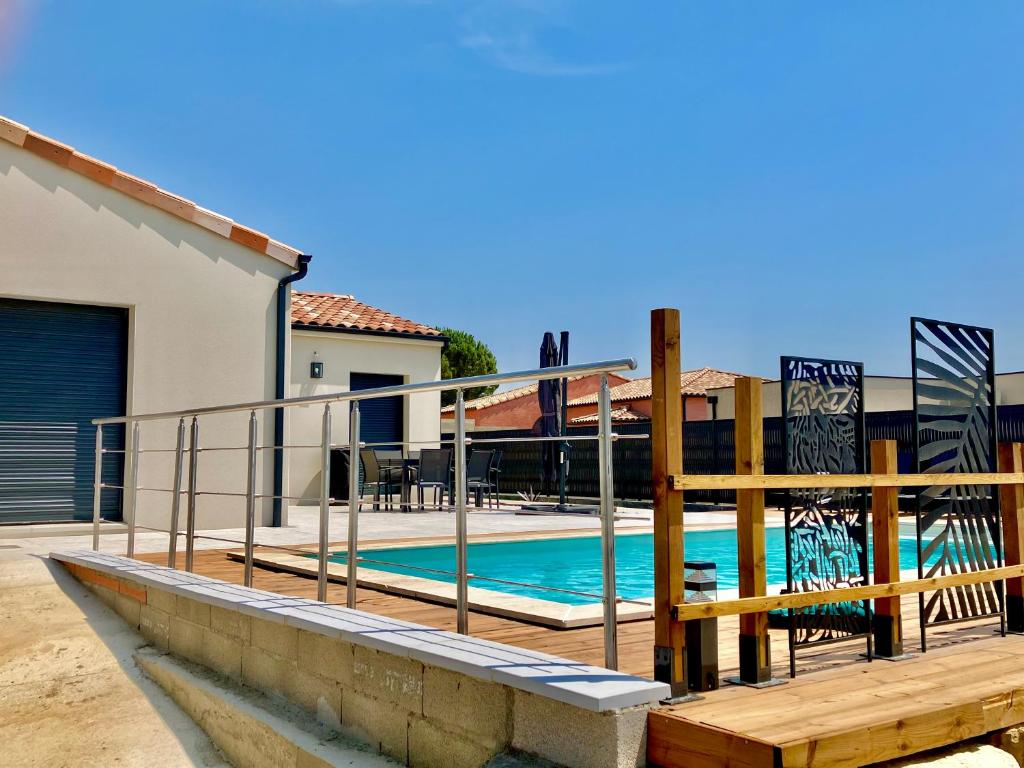 a swimming pool with a fence next to a house at Résidence Le Petit Duc in Carcassonne