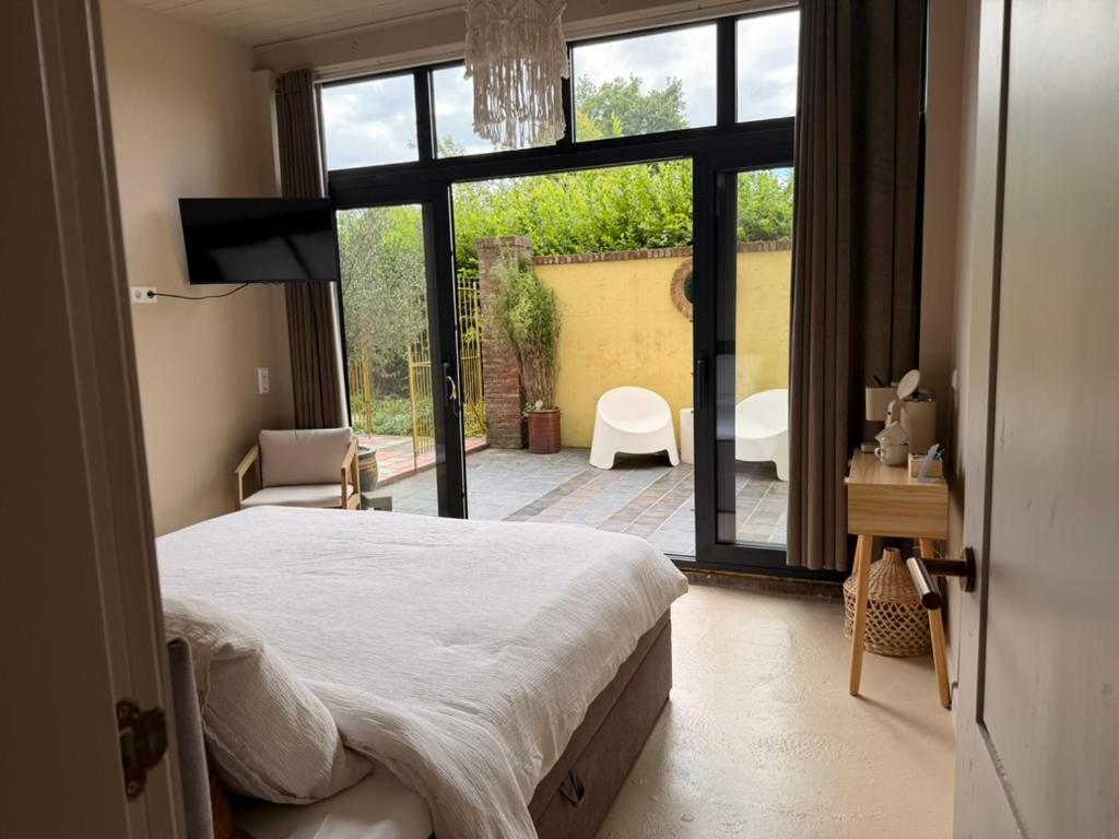 a bedroom with a bed and a view of a patio at Lizzy's B&B in Maarssen