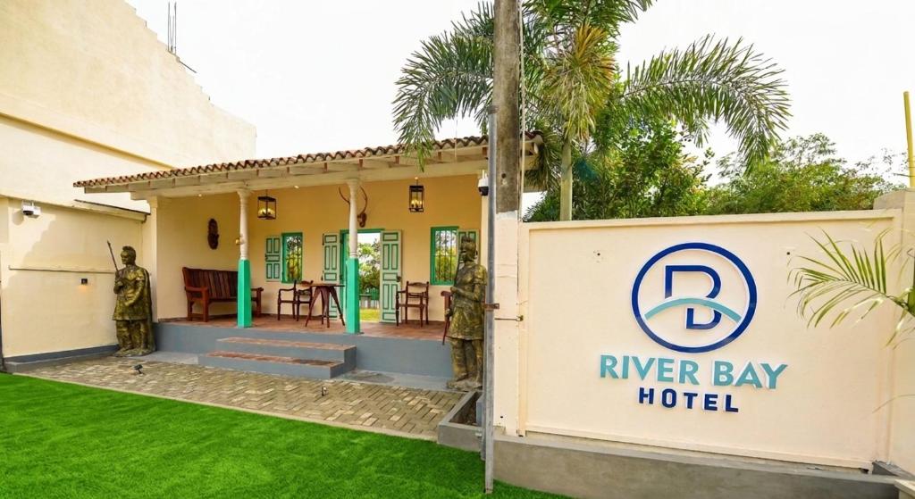 a sign in front of a river bay hotel at River Bay Hotel in Pillagoda