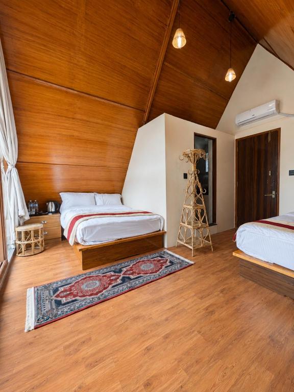 a bedroom with two beds and a wooden ceiling at Sukute River Hub Beach Resort in Dolālghāt