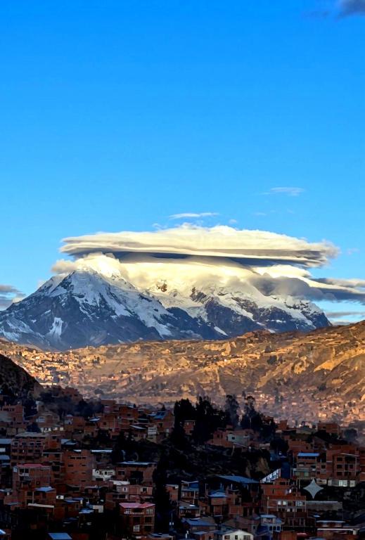an image of a mountain with clouds over a city at Hotel Berlina in La Paz