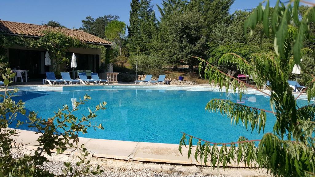 een groot zwembad met stoelen en een huis bij La Cigale in Les Arcs sur Argens