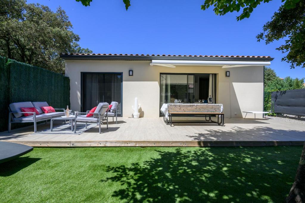 a patio with chairs and a table in a yard at Villa Npda in Carpentras
