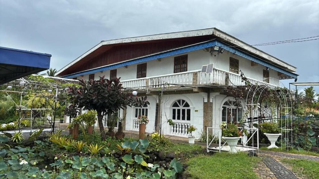 a white house with a balcony on top of it at Churinga Eco Resort in Tigaon