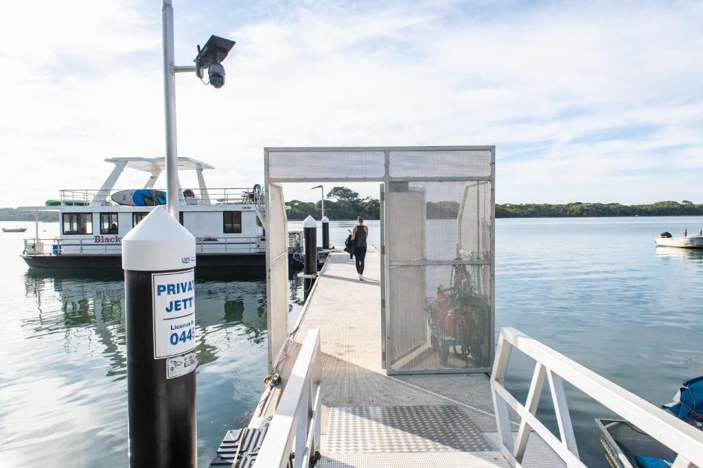 a dock with a boat in the water at Waterscape Floating Apartment in Augusta