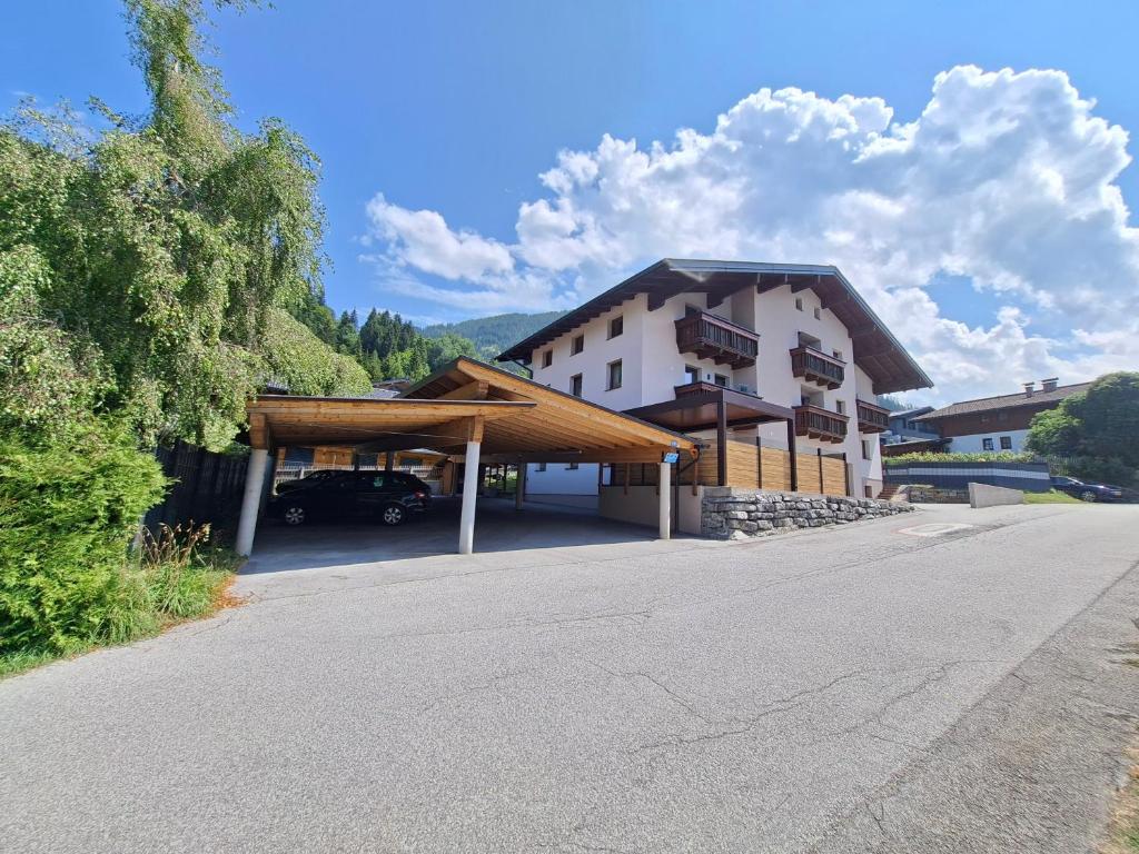 a building with a car parked in a parking lot at Mountainview Appartement mit Balkon und Carport in Flachau