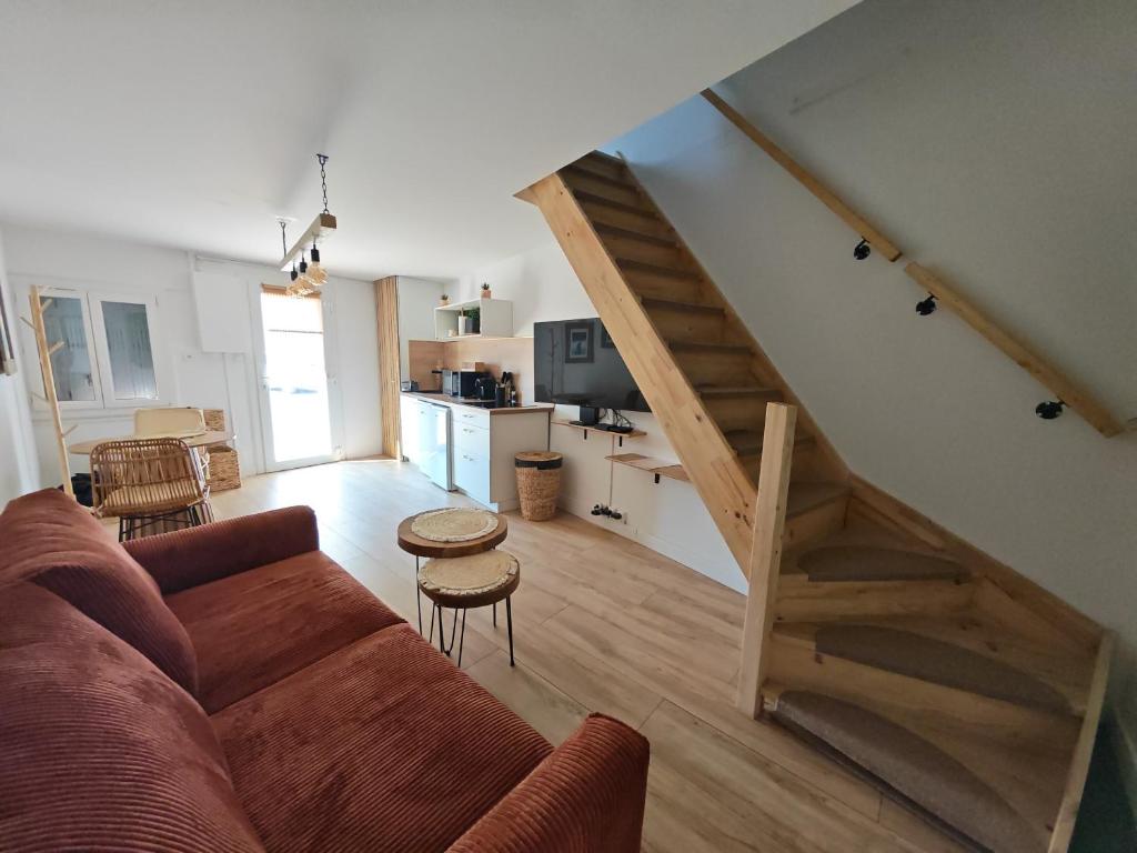 a living room with a couch and a staircase at l'alcôve in Frontignan