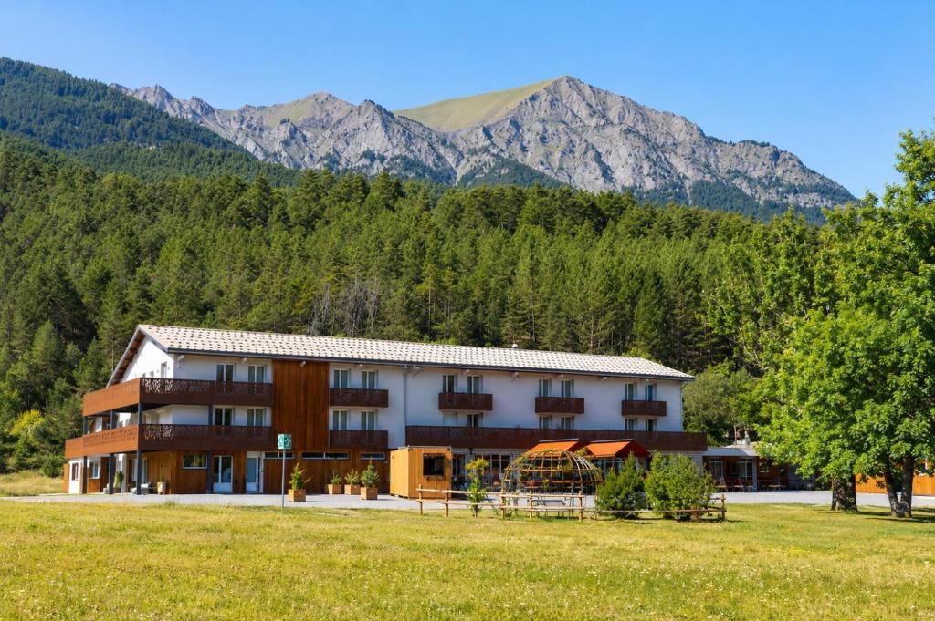 a large building with mountains in the background at Mille100-47 - Ubaye Base Camp in Faucon-de-Barcelonnette