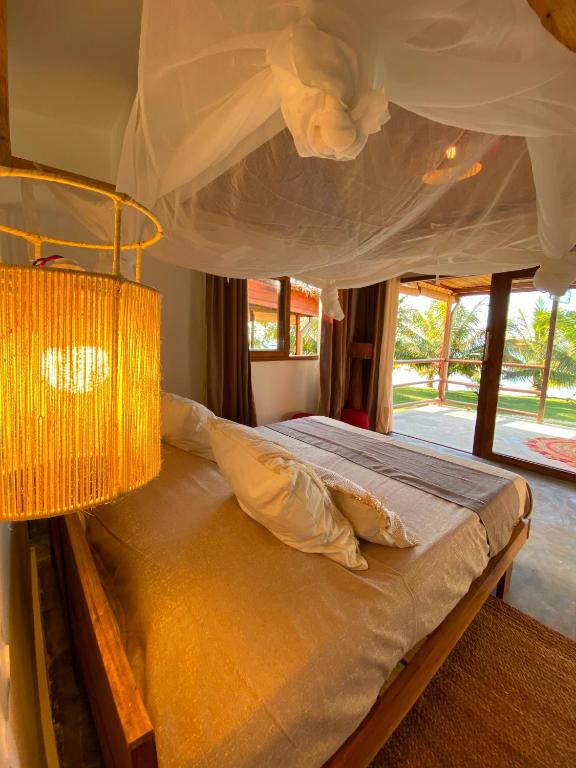 a bedroom with a bed with a chandelier at Ankavia Lodge in Sainte Marie