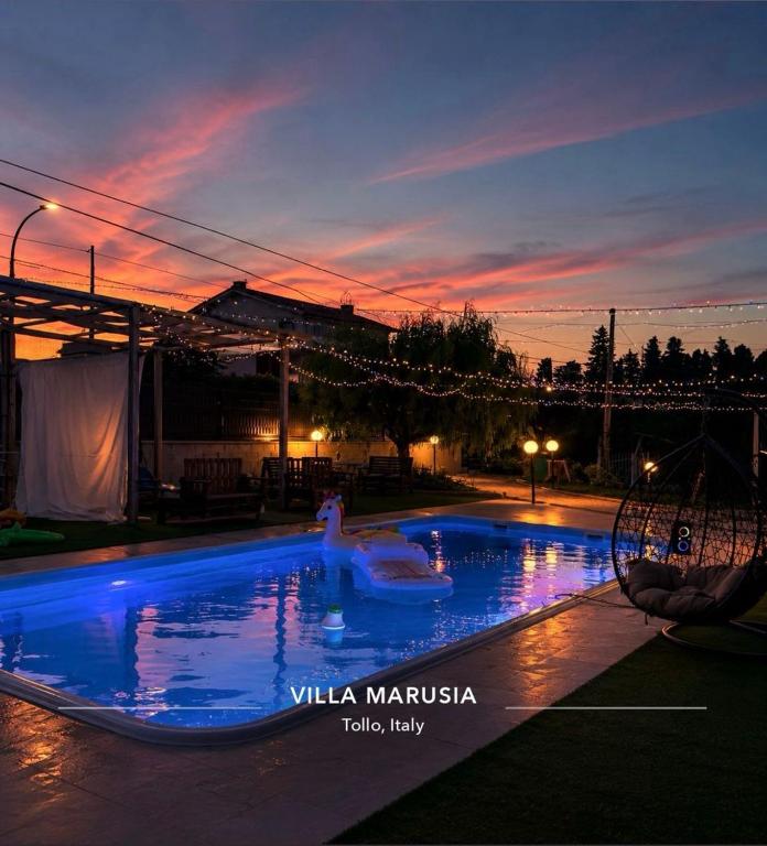 a person in a swimming pool at night at Villa Marusia in Tollo