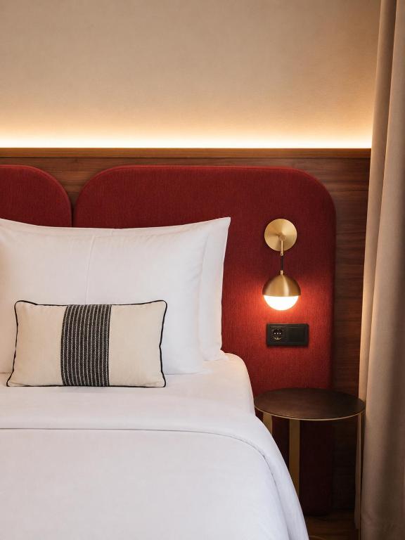 a bedroom with a white bed with a red headboard at Carlton Boutique Hotel - NEW OPENING in Vienna