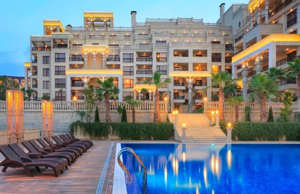 a hotel with a swimming pool in front of a building at ЛУКСОЗЕН АПАРТАМЕНТ В 4 звезден хотел in Golden Sands