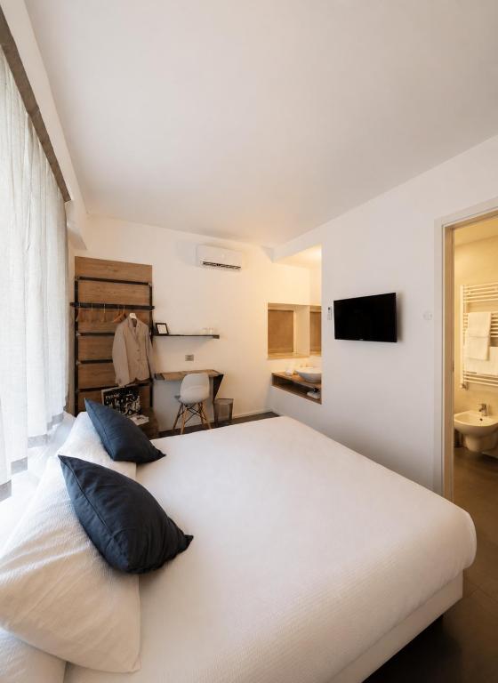 a bedroom with a large white bed with two pillows at Le Palme City Rooms & Breakfast in Trento