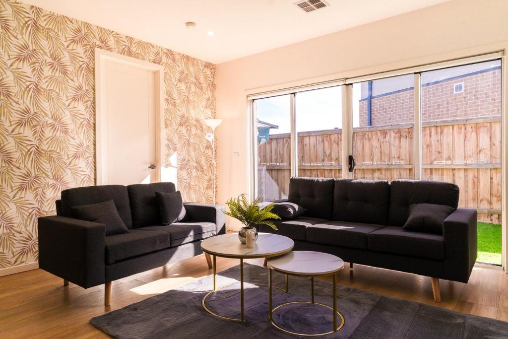 a living room with two black couches and a table at Light-Filled Werribee Escape in Werribee
