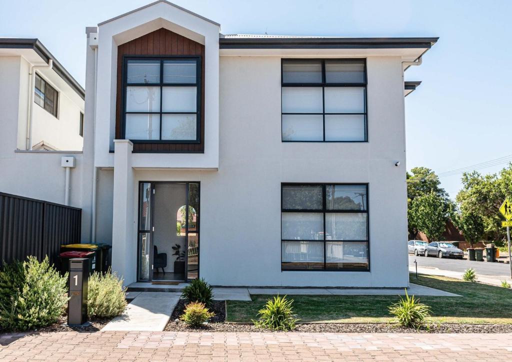 a white house with black windows at Home Abroad in Ascot Park